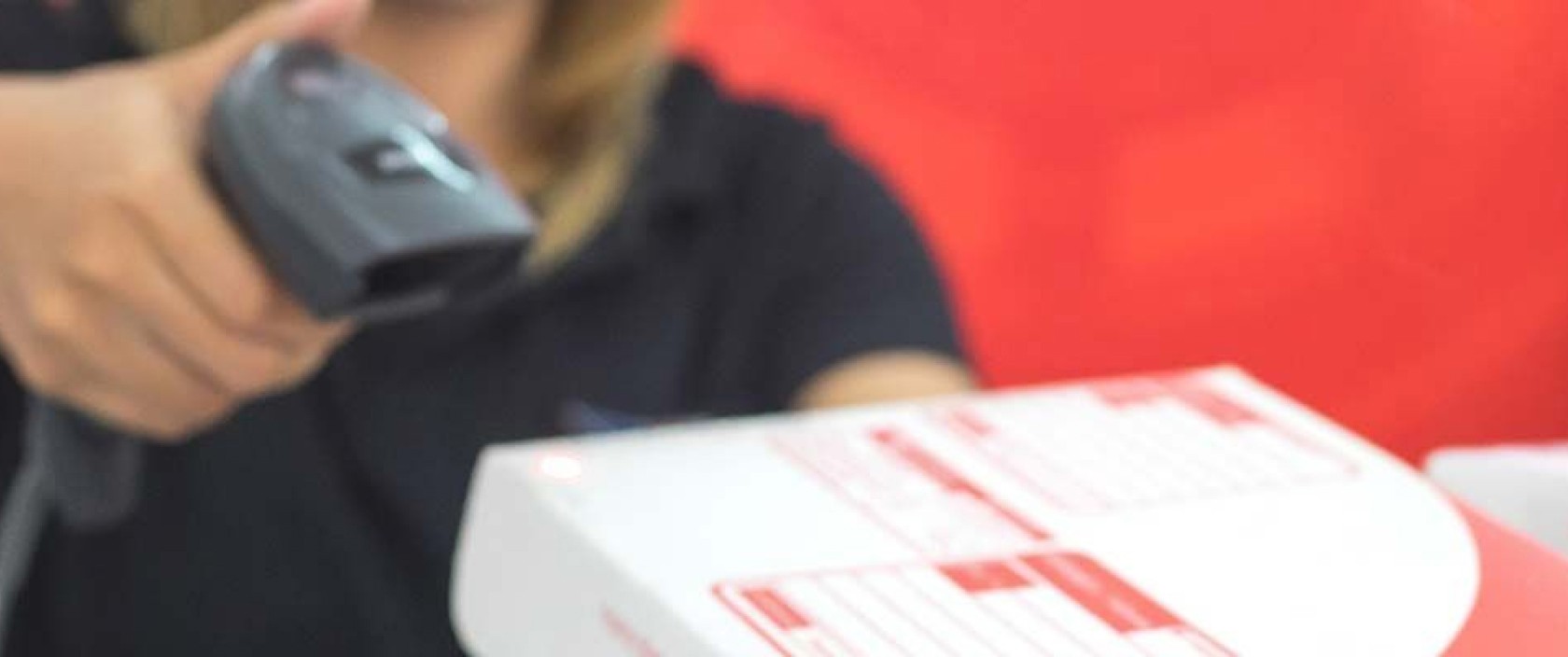 A postal worker scans a Canada Post flat rate box.