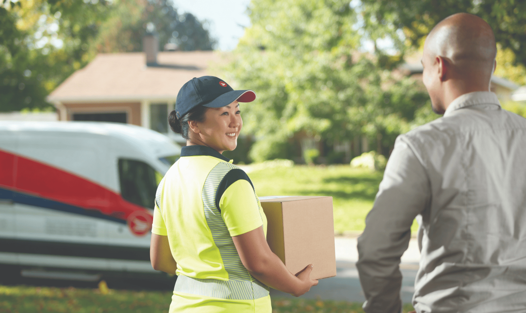 A delivery agent picks up a package at a customer’s home.