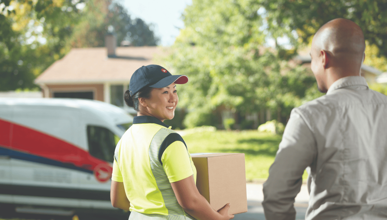 A delivery agent picks up a package at a customer’s home.