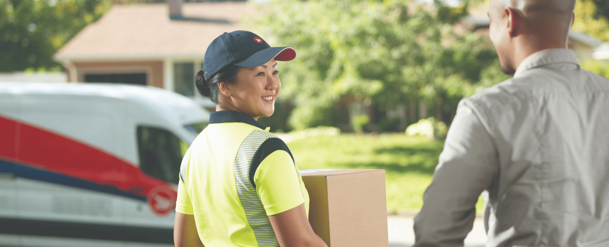 A delivery agent picks up a package at a customer’s home.