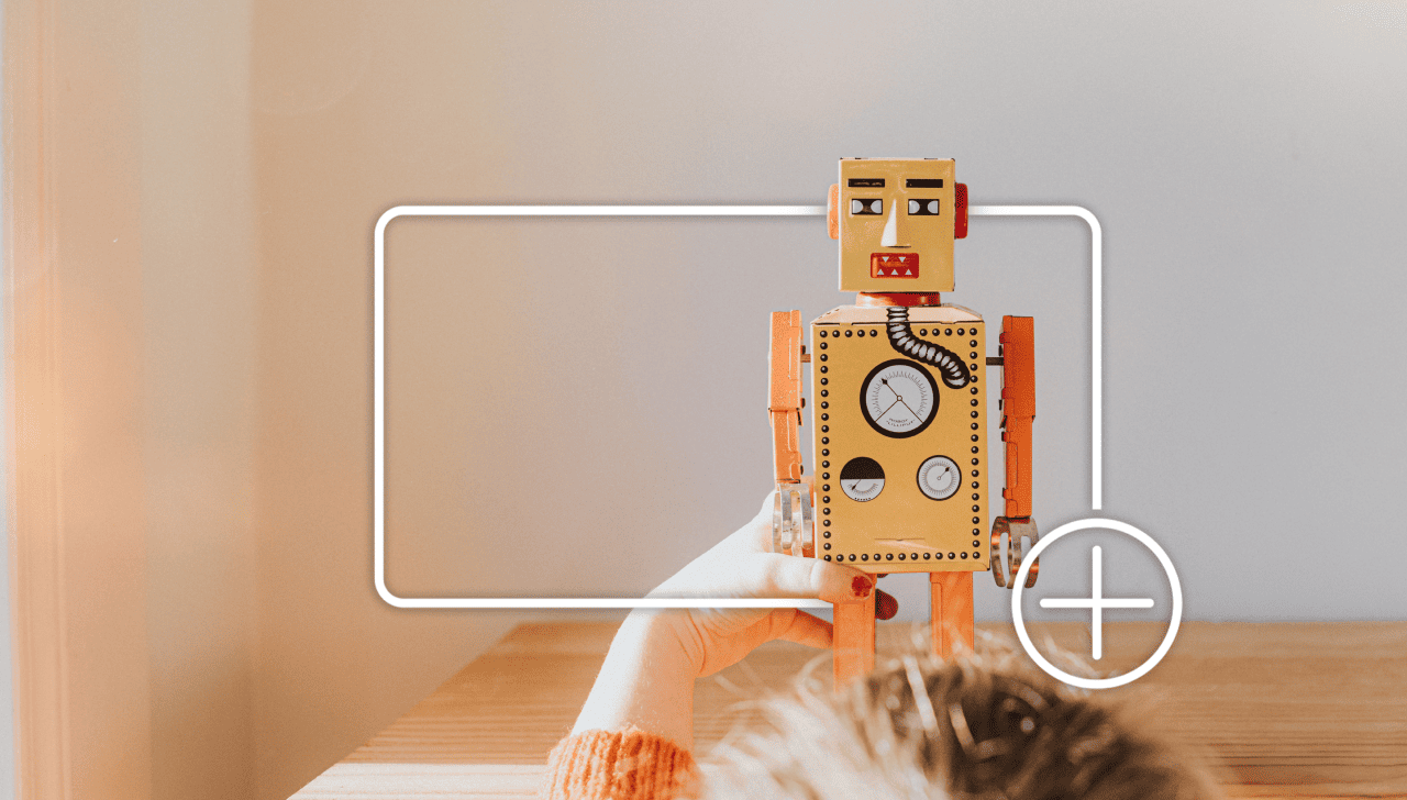 A child plays with a toy robot, framed by a white focus box with a plus icon, indicating adding to an online shopping cart.