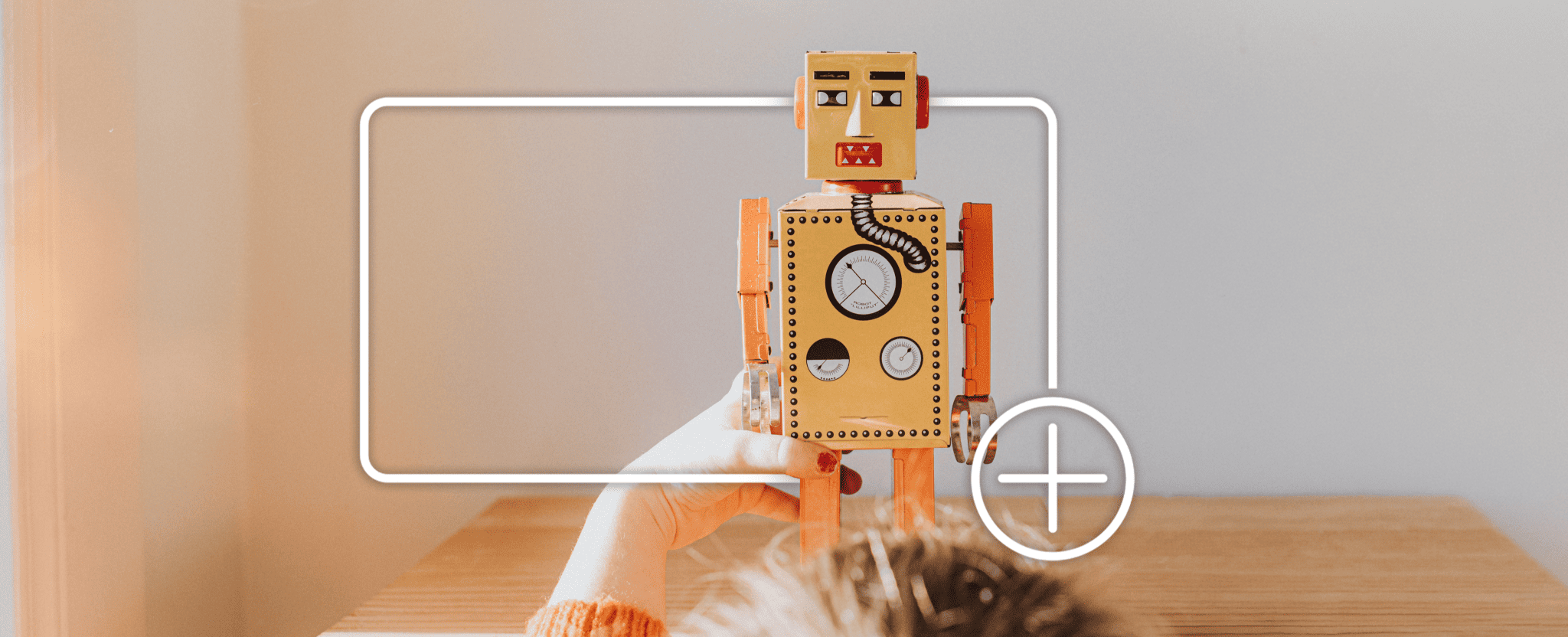 A child plays with a toy robot, framed by a white focus box with a plus icon, indicating adding to an online shopping cart.