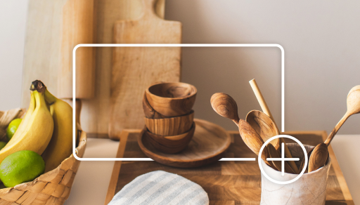 Wood kitchenware on a countertop. Items are outlined by a white box and plus sign graphic that indicates adding to an online shopping cart.